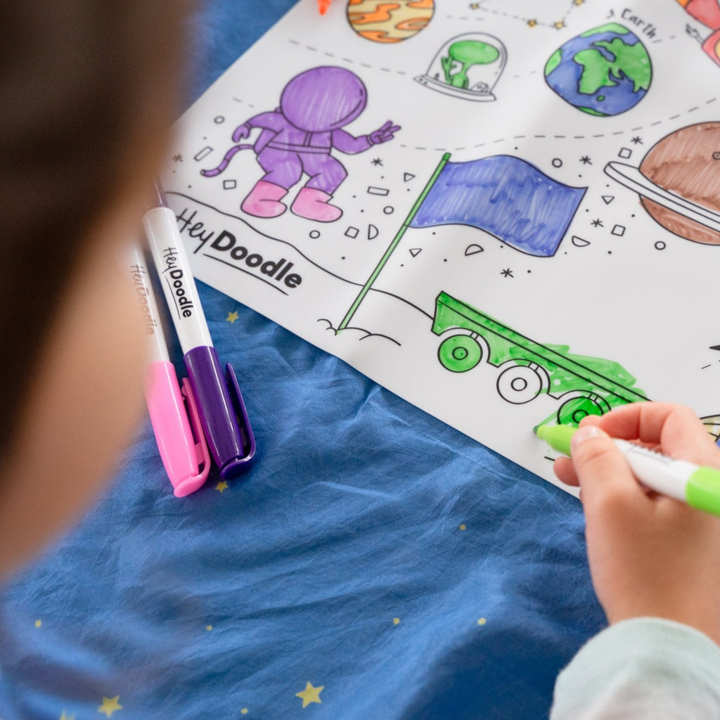 Child coluring in outer space reusable mat from hey doodle