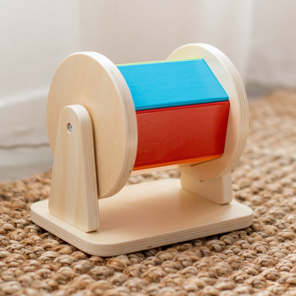 The Totli Spinning drum for babies displayed on rug