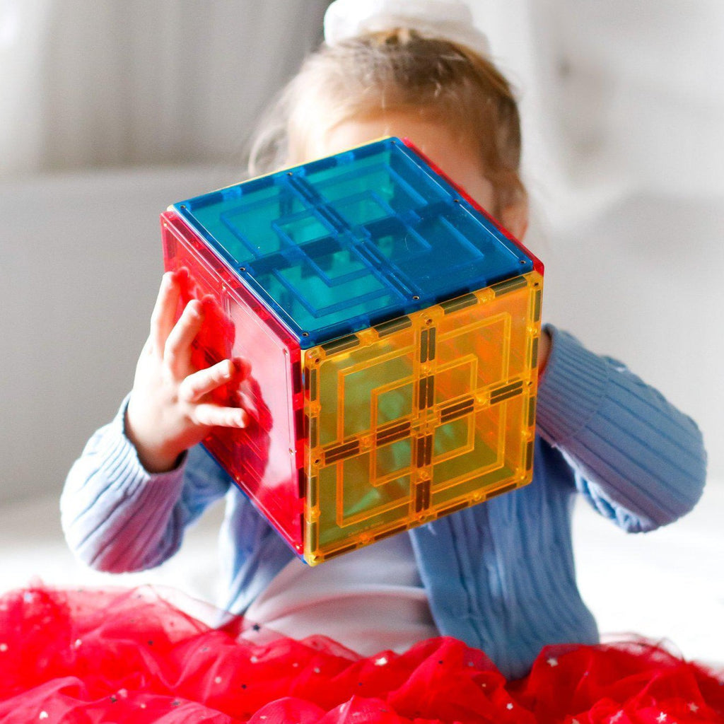 Girl playing with the new large square magnetic tile pack and created a cube