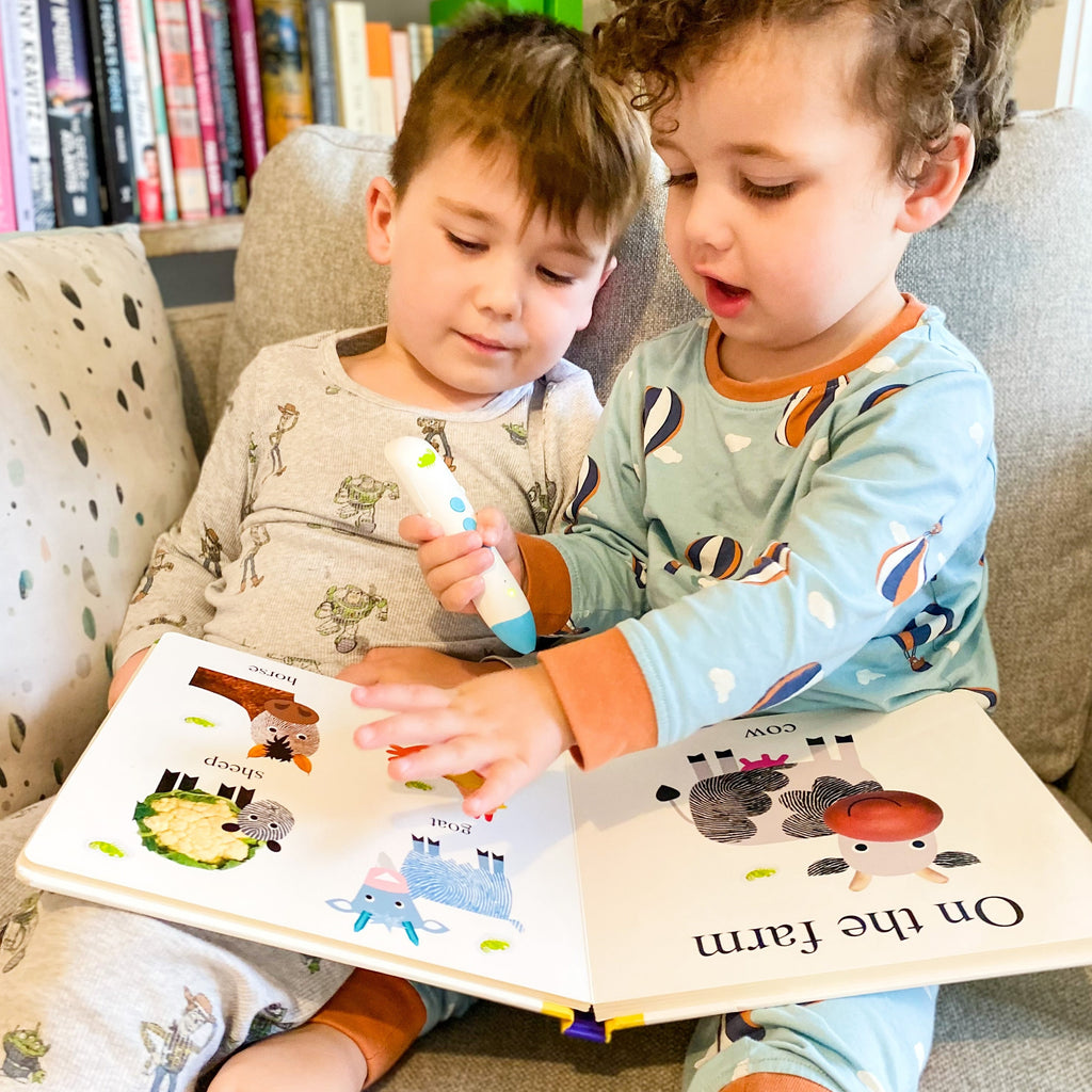 Brothers reading a book using chameleon reader, audio pen