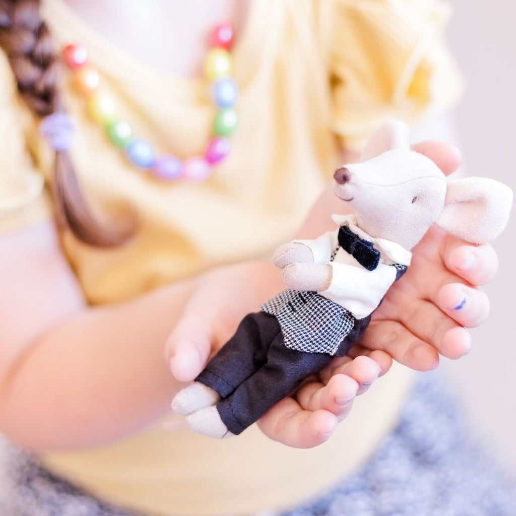 Child holding Maileg Waiter mouse in hands