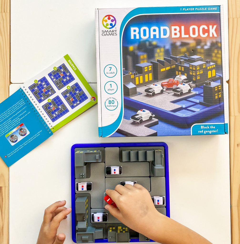 Child playing with road block game set up on Ikea Flisat table