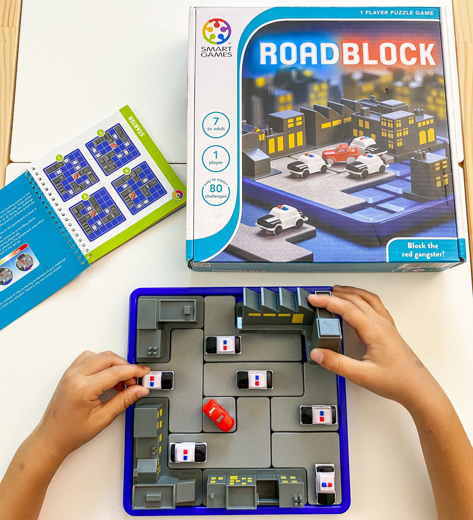 Child playing with road block game set up on Ikea Flisat table