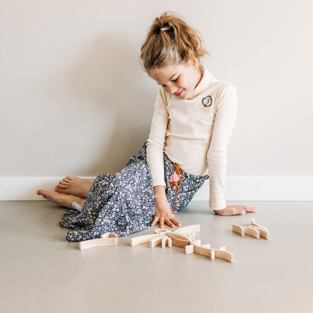 Girl playing with abel wooden blocks 