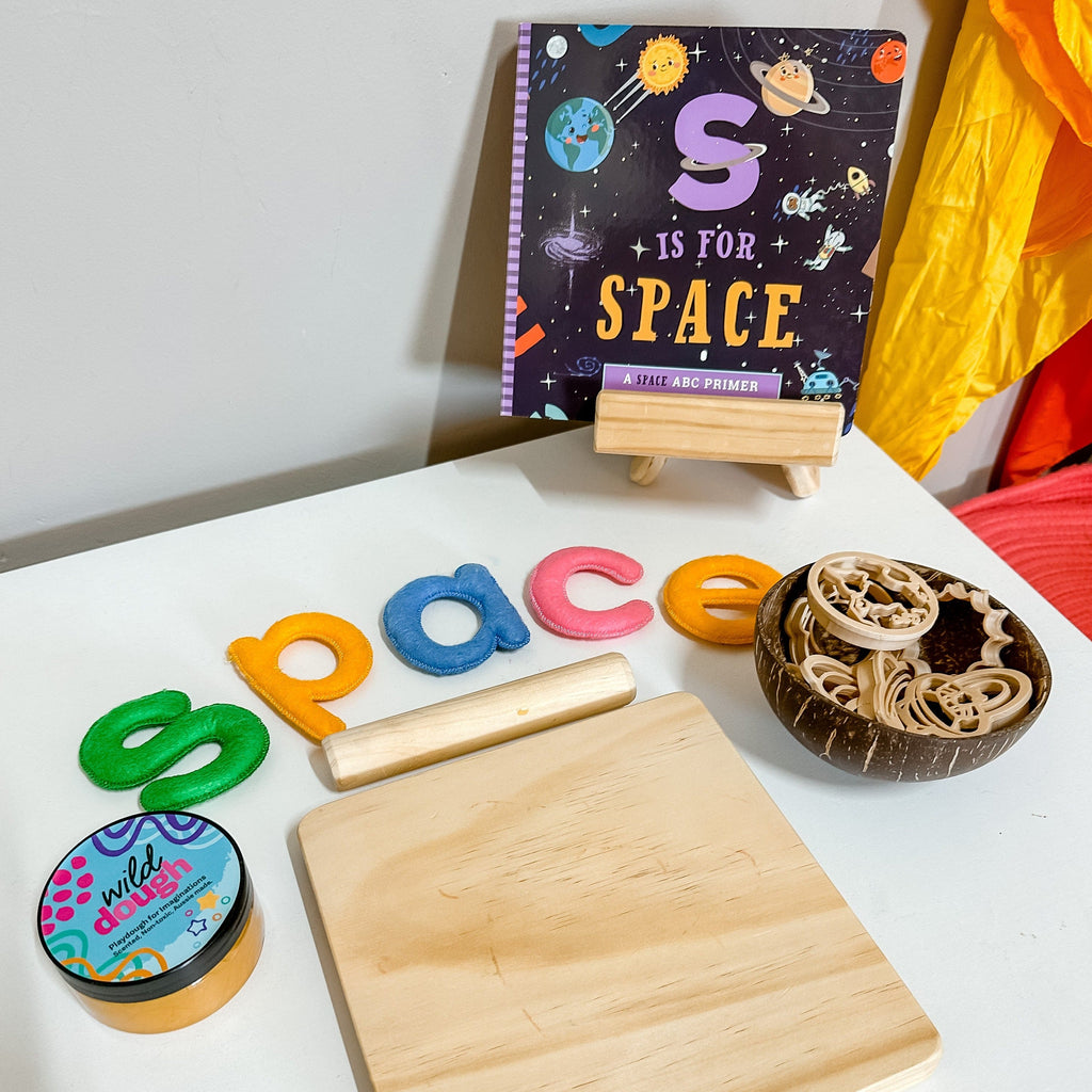 S is for Space book in background with playdough set up and SPACE in letters