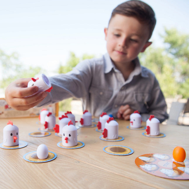 Boy playing Fat Brain Toys Peek-A-Doodle Doo- chicken and egg game