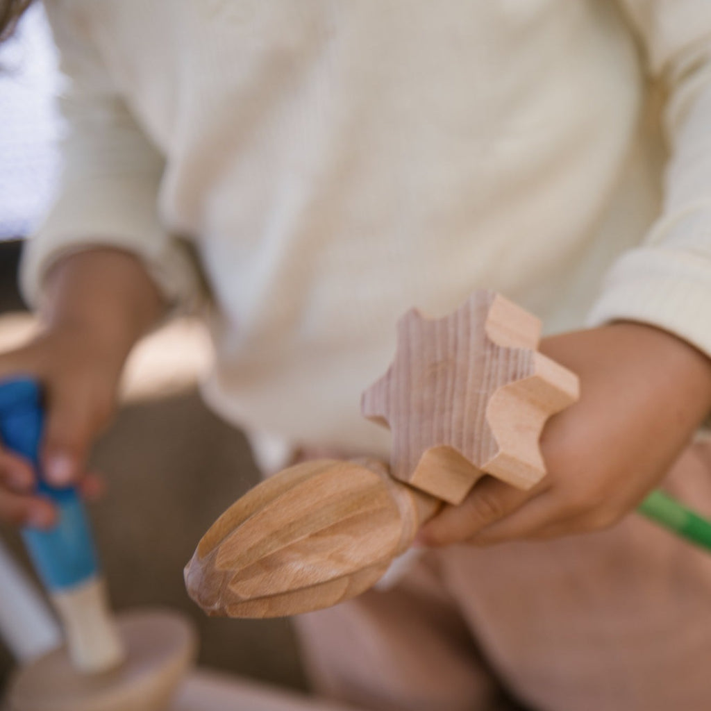 Child holding wooden Grapat Tools in hand