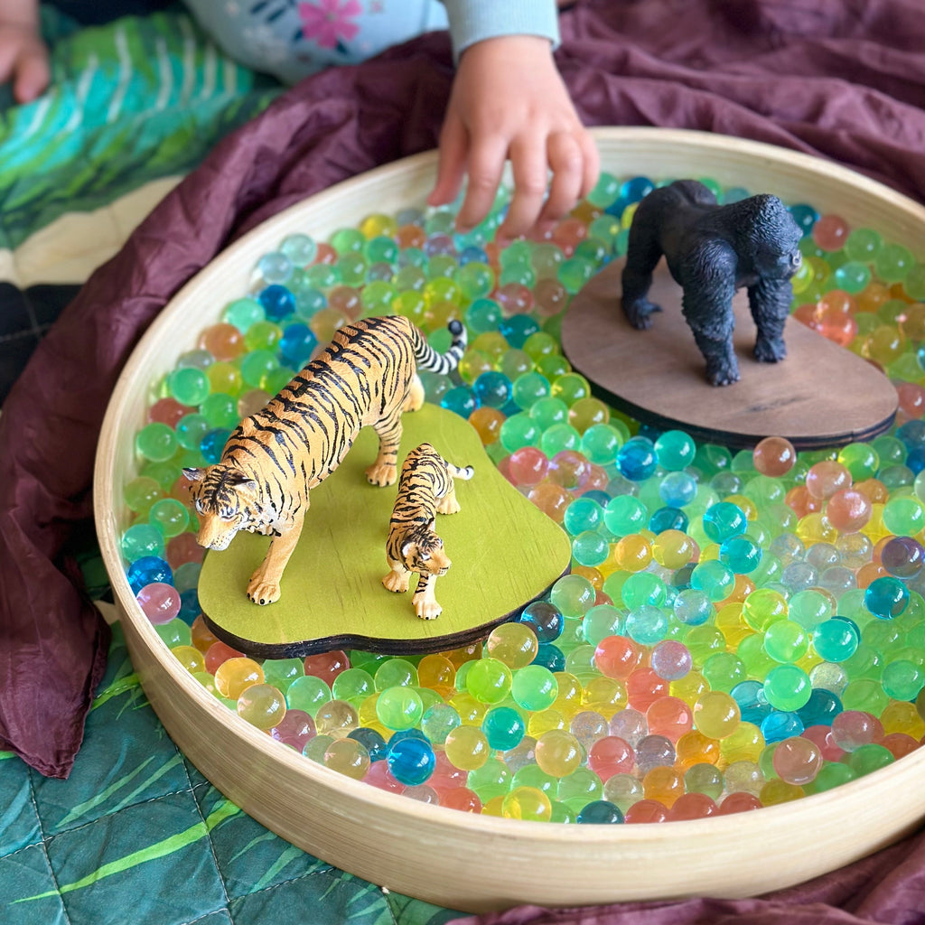 Wild animals from CollectA monthly subscription sitting in a sensory tray with water beads 