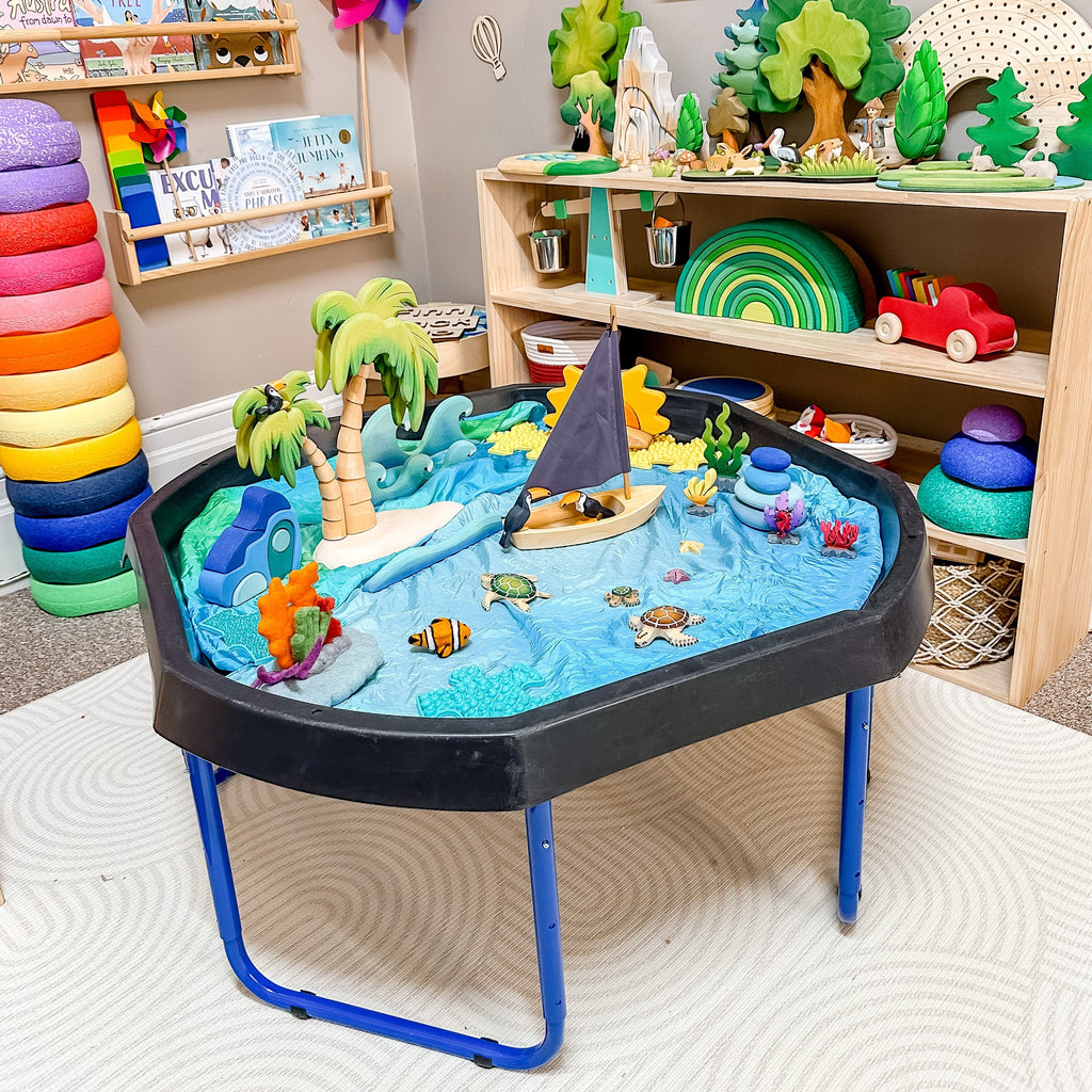 Large tuff tray with stand sitting in colourful playroom with small world set up 