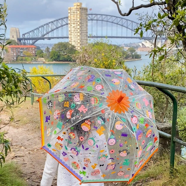 Colour changing pvs kids umbrella held by child looking at the sydney harbour bridge