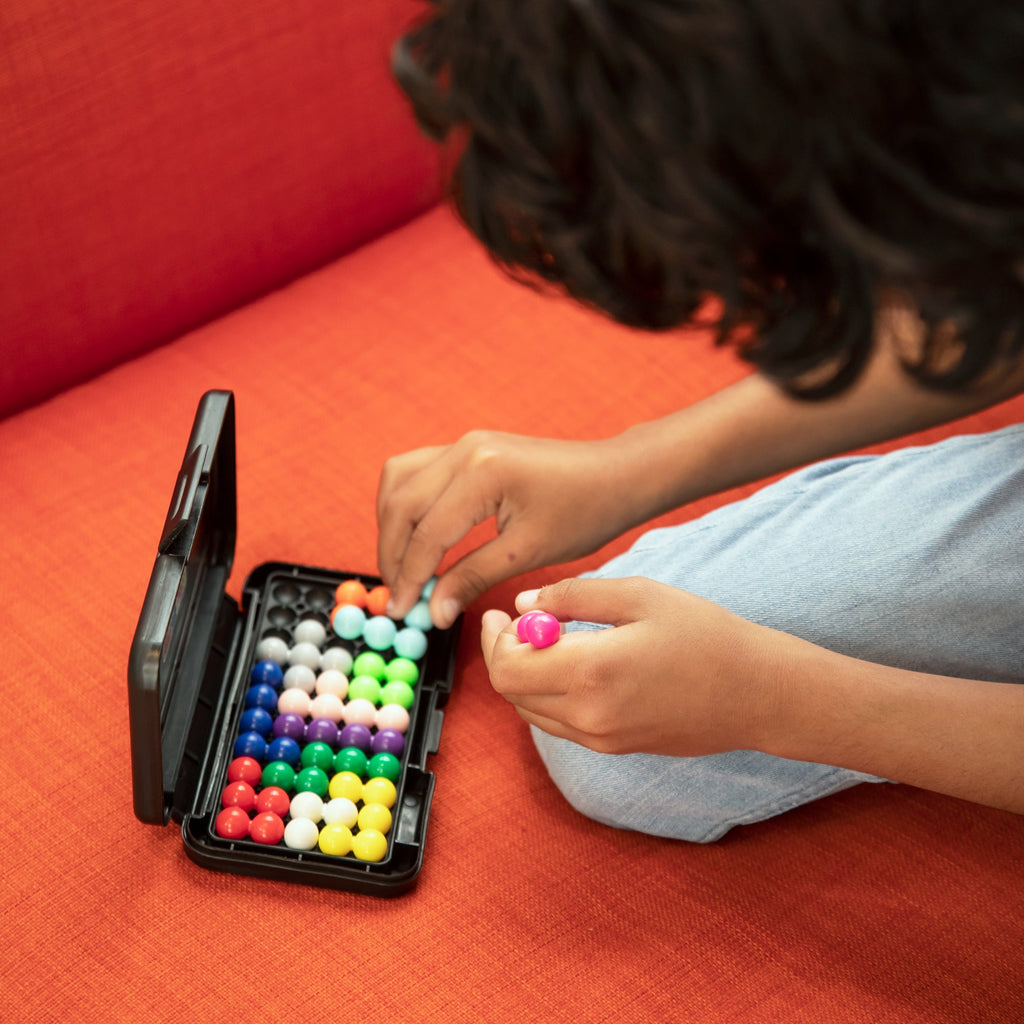 Child playing with Kanoodle puzzle game