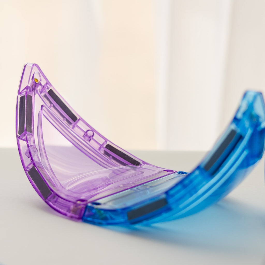 Pastel magnetic tile curved triangles on a white surface with a blurred background