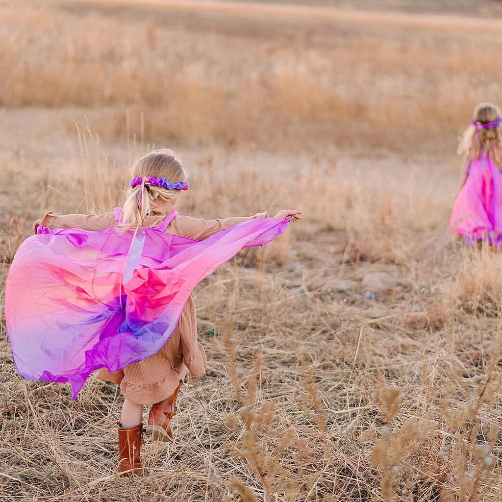 Girls running through hills with blossom fairy wings on 