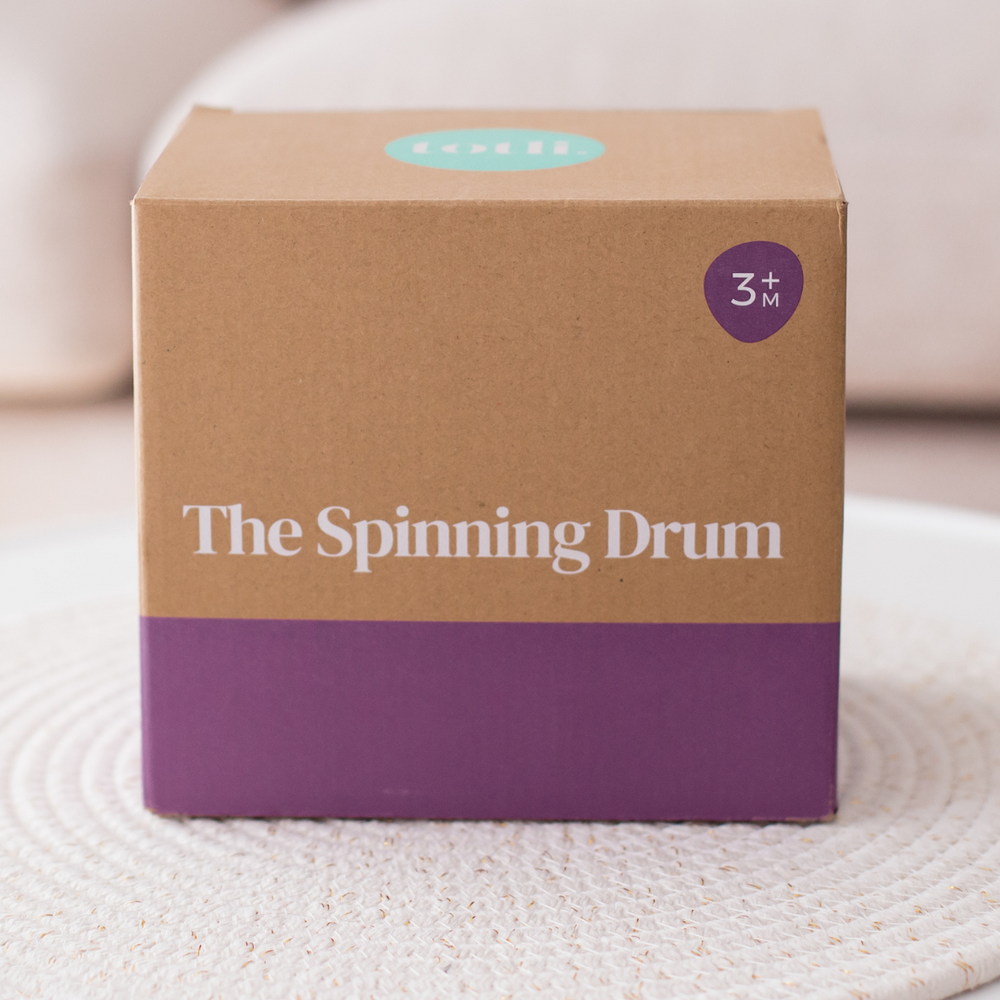 Totli Spinning drum in packaging sitting on rug
