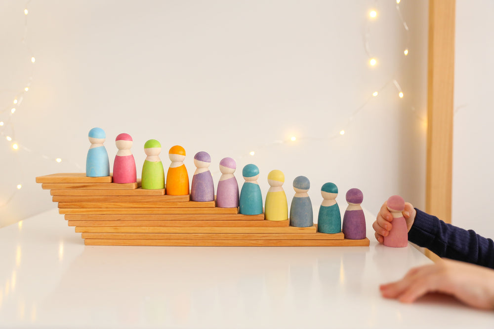 Grimm's building boards in natural stacked with grimm's pastel rainbow friends