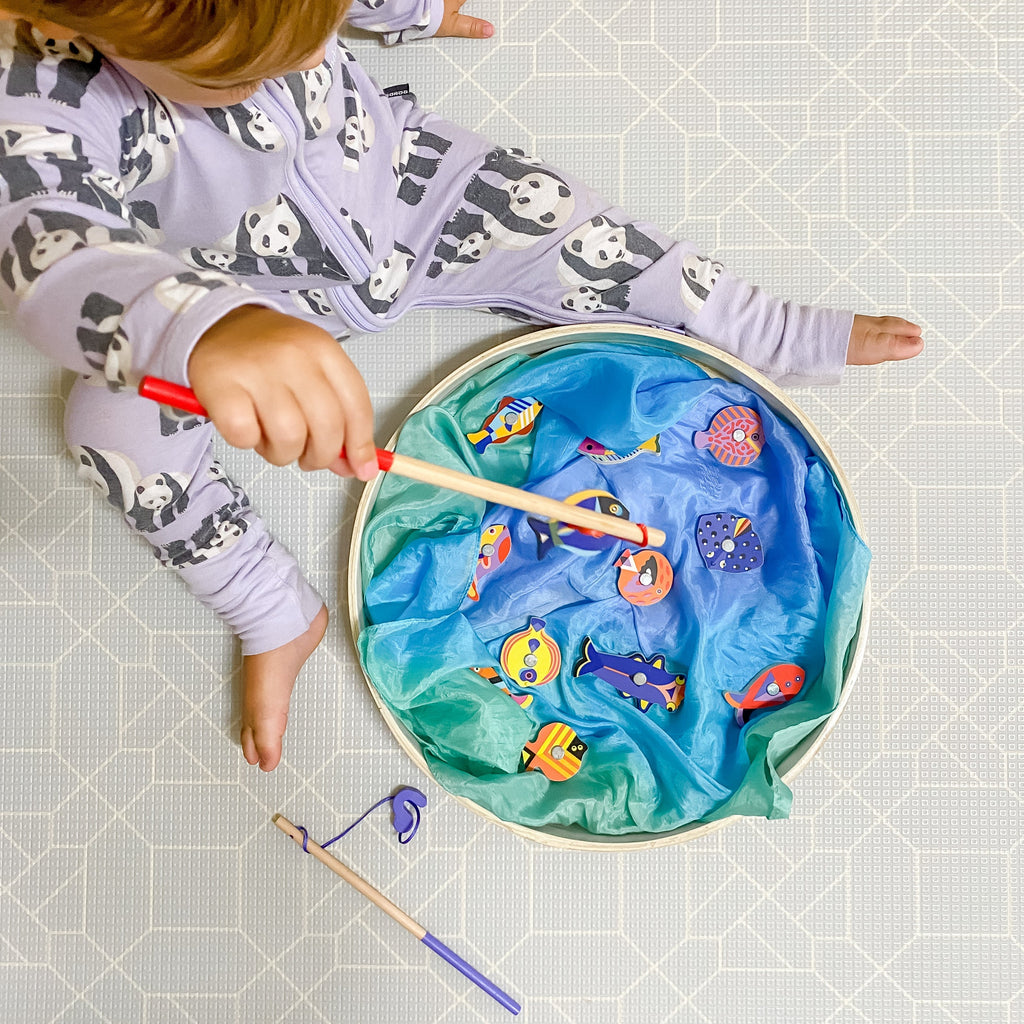 Djeco Magnetic graphic fishing set up in tray with silks and toddler playing
