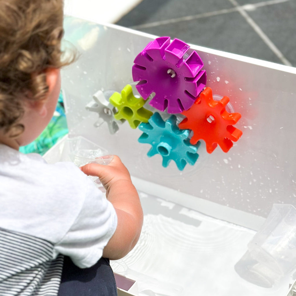 Child playing with Cogs set up outside
