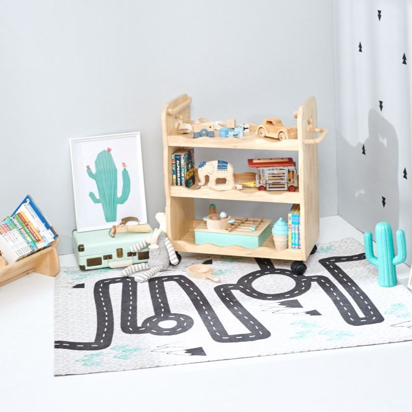 Bunny Tickles Solid Wood Trolley displayed with toys in the corner of a playroom with a roadmap playmat and cactus print