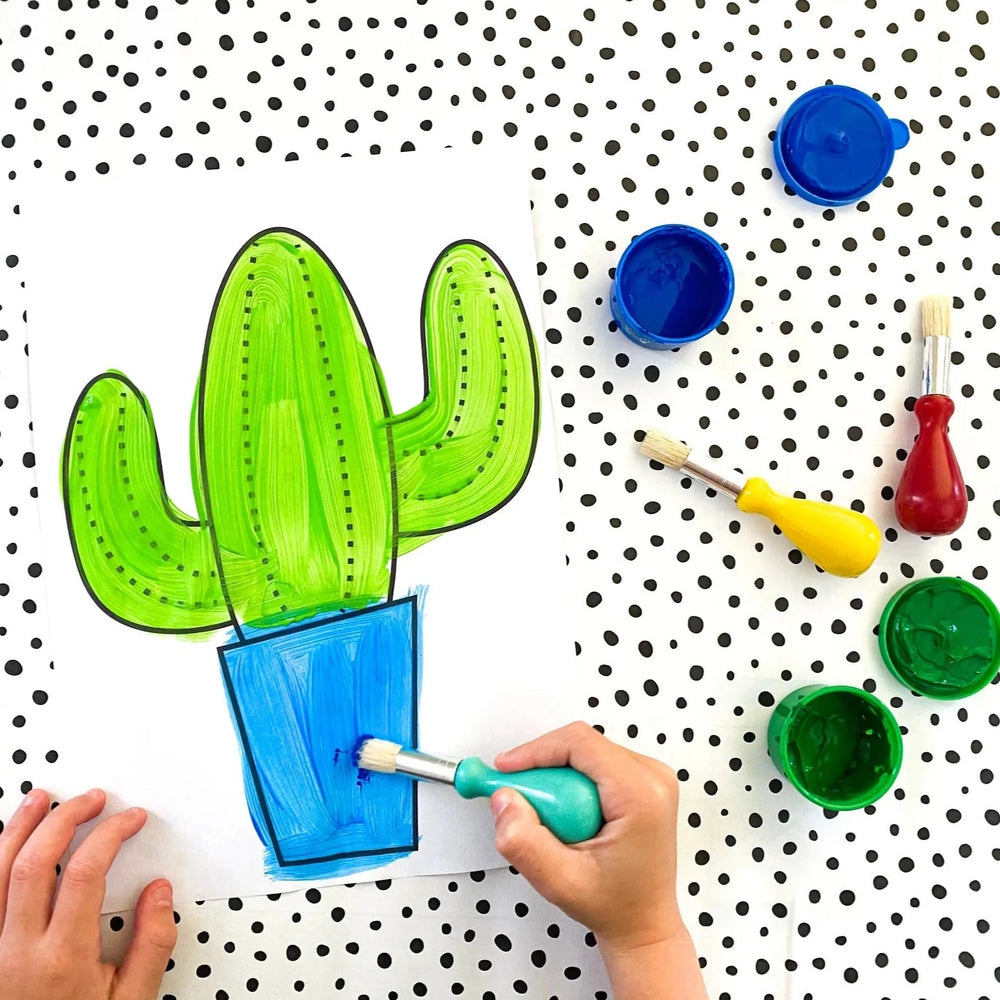 Paint brushes for kids with painted picture of cactus on spotty background with tubs of paint