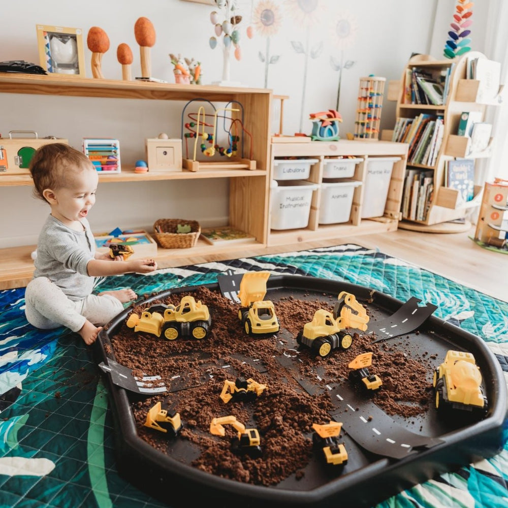 Construction tuff tray set up with colourful play mat and child playing