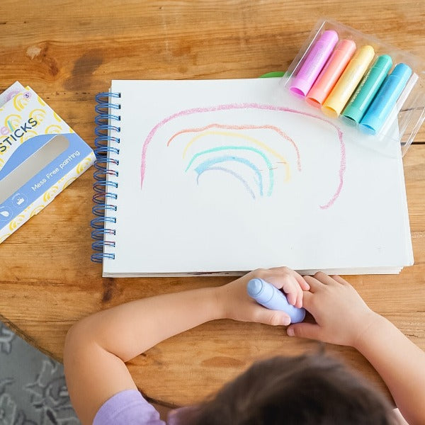 Child painting rainbow with Pastel Paint Sticks