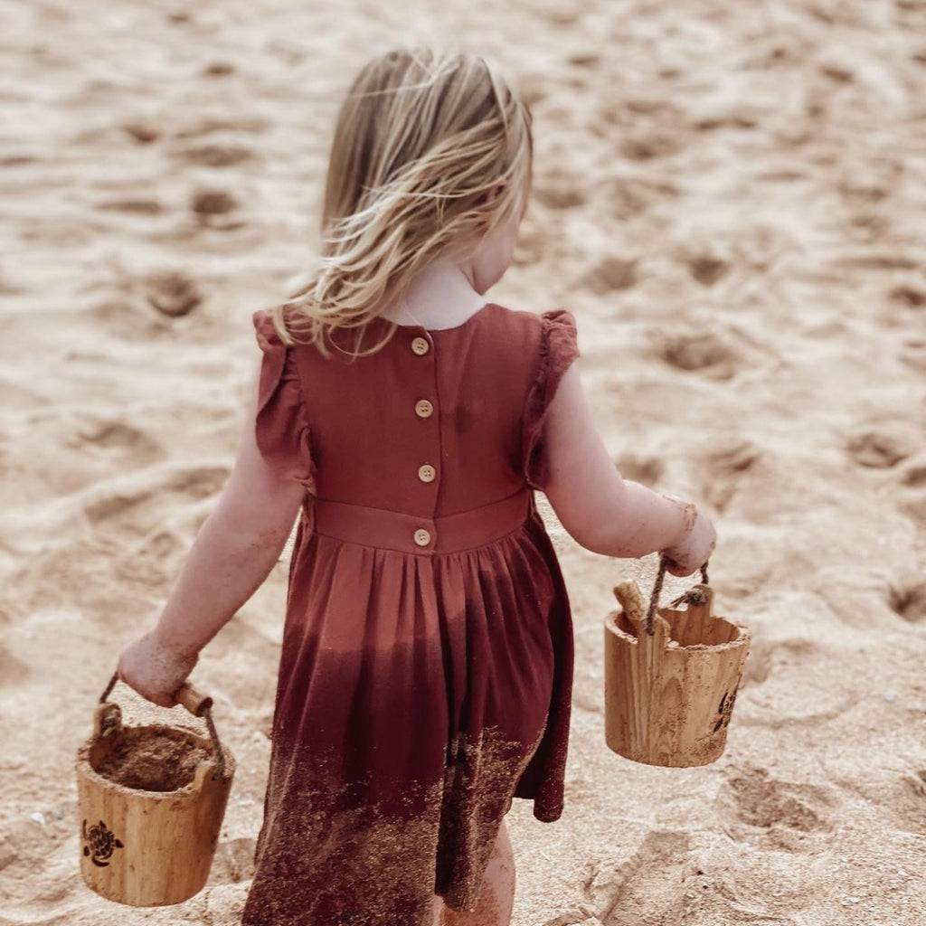  Girl in brown dress holding 2 Explore Nook Wooden Buckets in turtle burn stamp edition