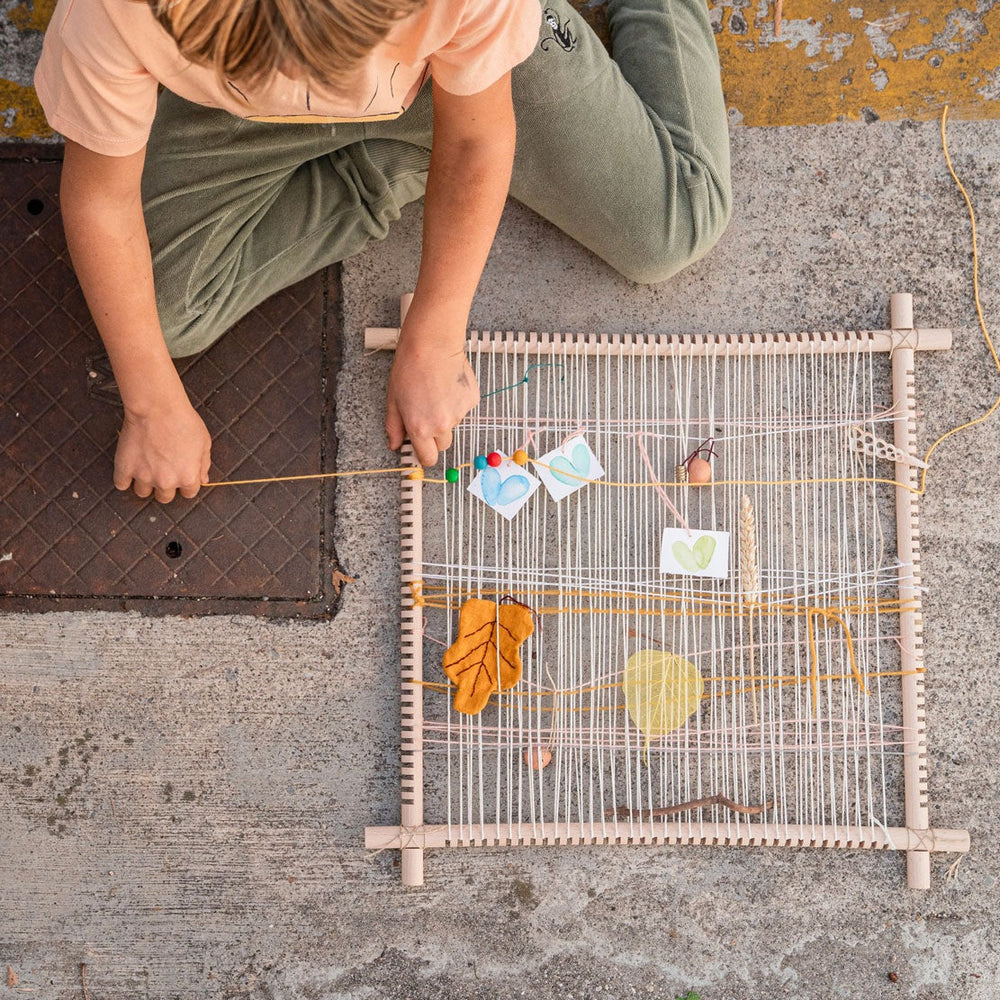 Child using Grapat frame to weave and create