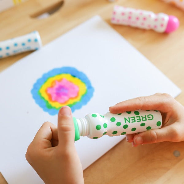 Green dot marker being used to create a rainbow flower 