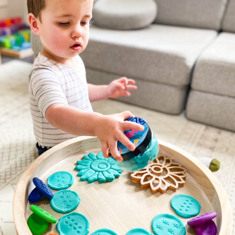 Toddler playing with playdough and stampers from 0-2 Play Subscription Box