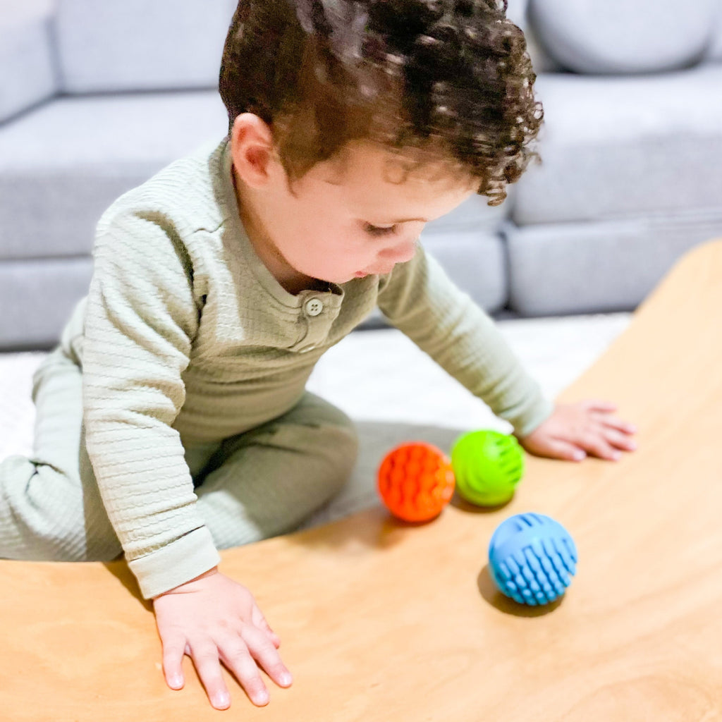 Fat Brain Toys - Sensory Rollers being played with by a toddler on a wobbel board