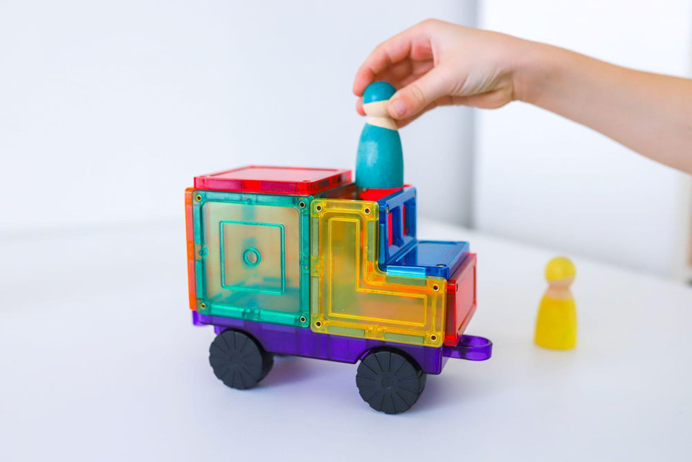 Brightly coloured magnetic truck from Learn and Grow car pack with child placing wooden peg person inside