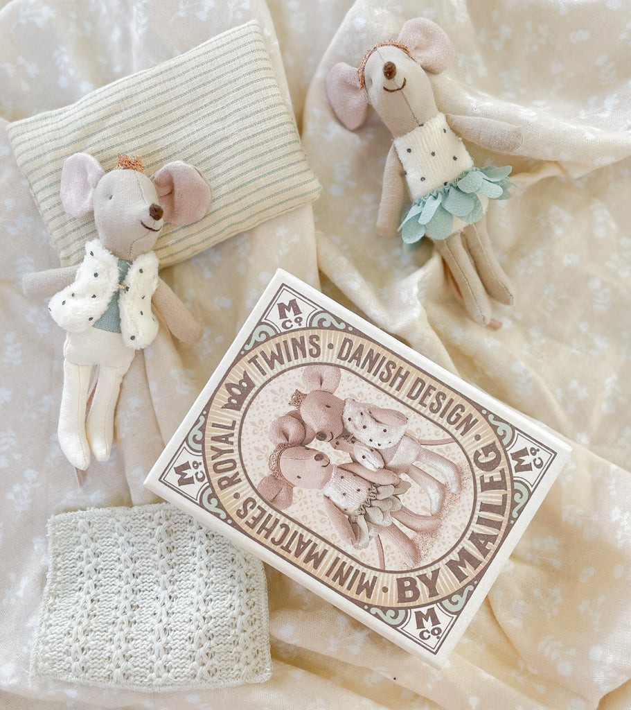 Royal twin mice sitting out of their box  on a cotton bedspread