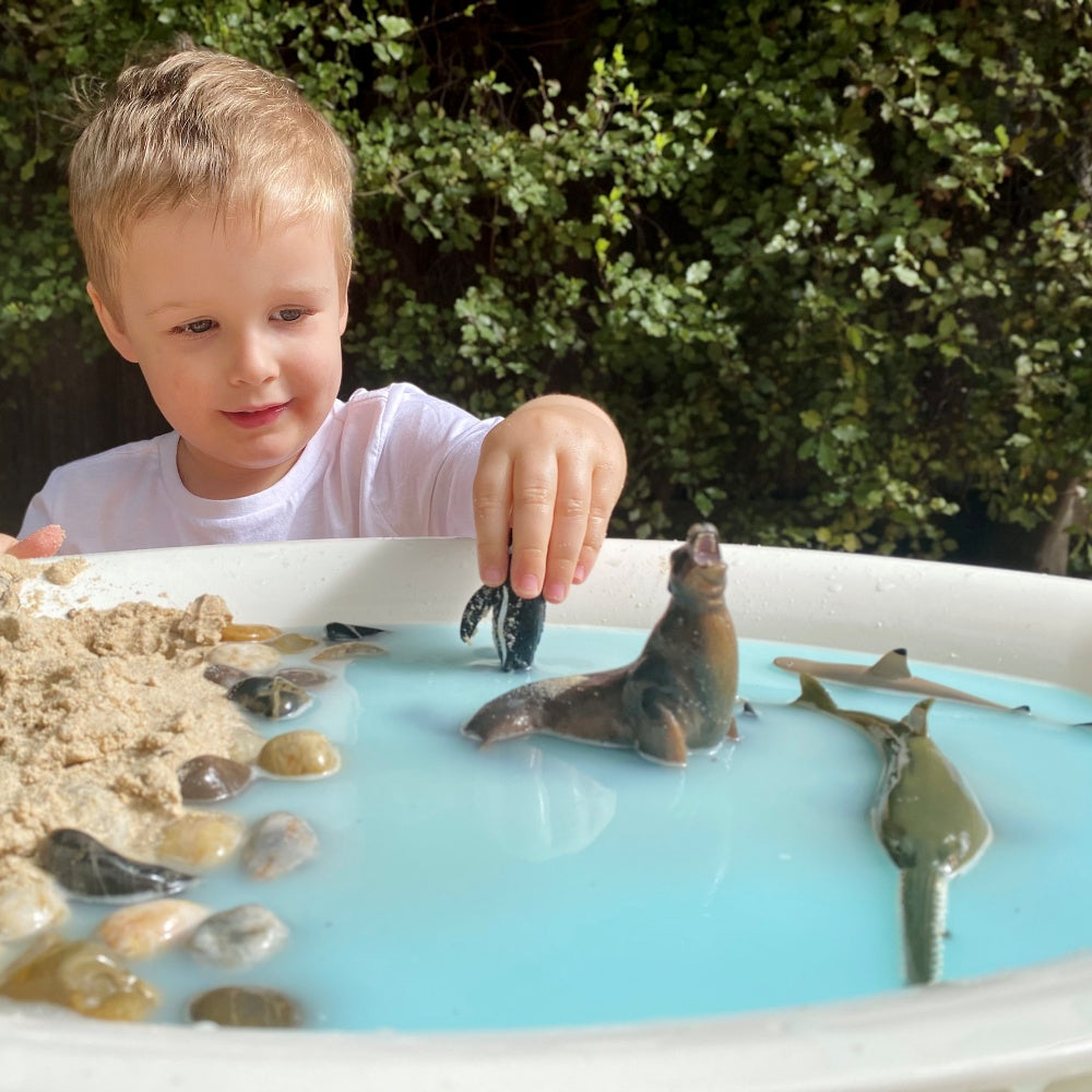 child playing with ocean themed animals from collecta subscription box outdoors