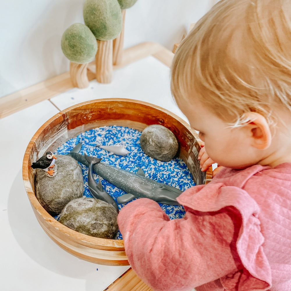 child playing with ocean themed animals from collecta subscription box with coloured rice