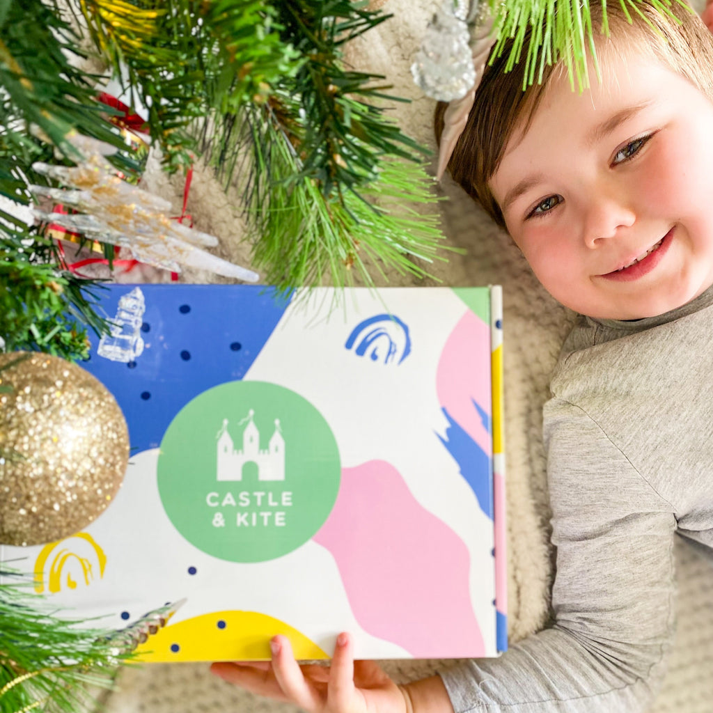 Boy holding Castle and Kite Christmas Craft kit under Christmas tree