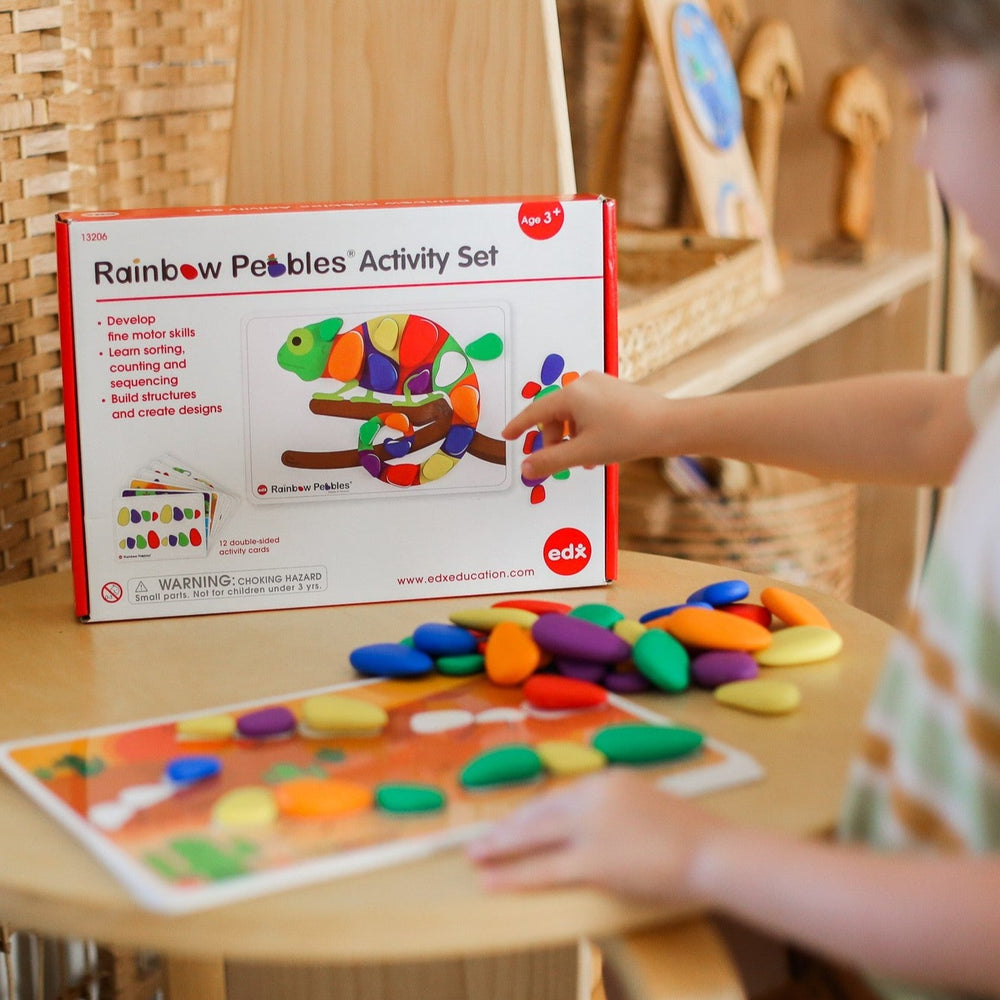 Edx Rainbow pebble activity set in box with child 
