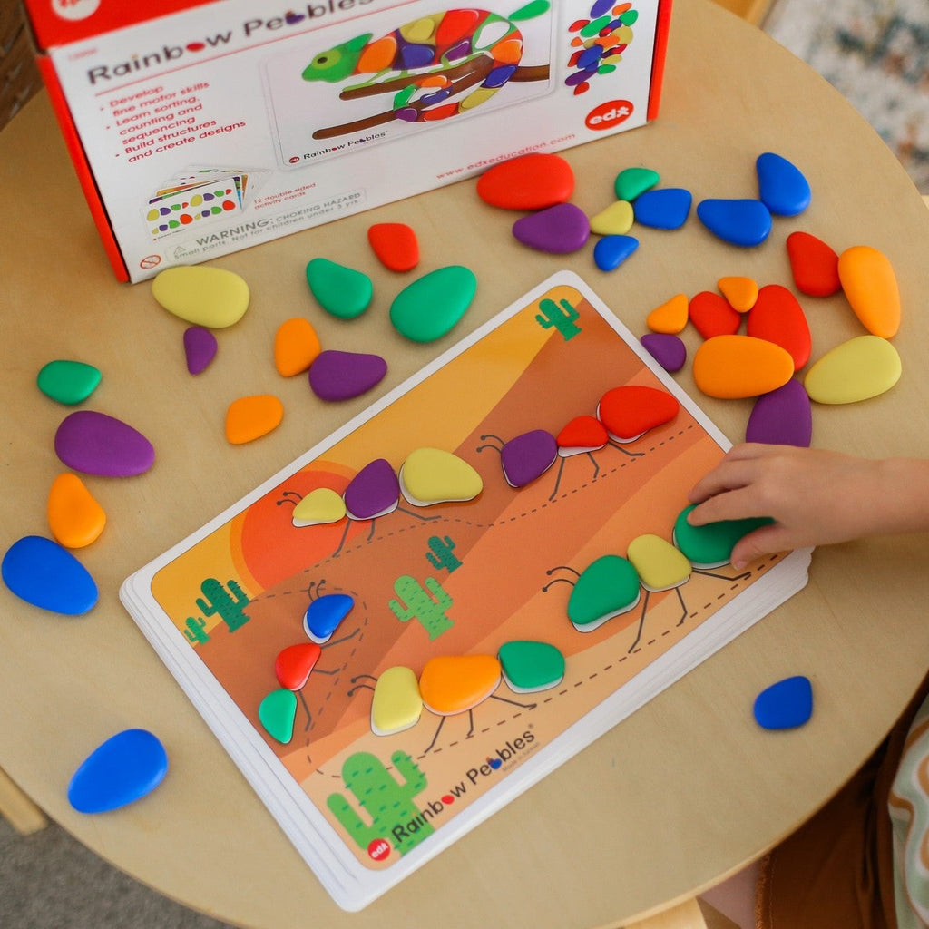 Child playing with rainbow pebble activity set with card 