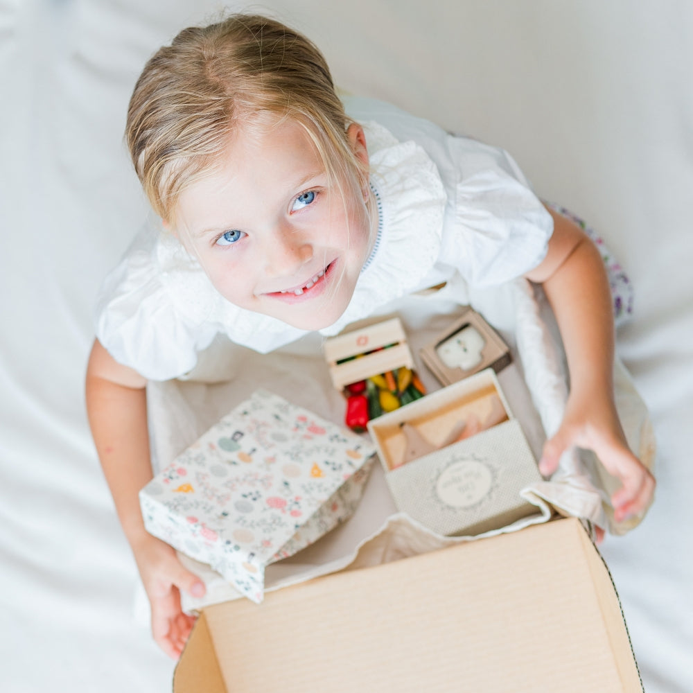 Girl holding Monthly Maileg Subscription box sitting down