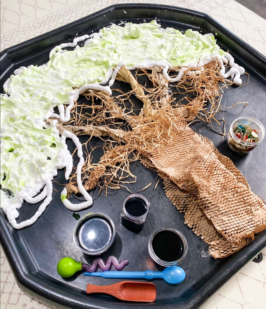 Autumn messy play set up with autumn tree and sensory materials in a tuff tray