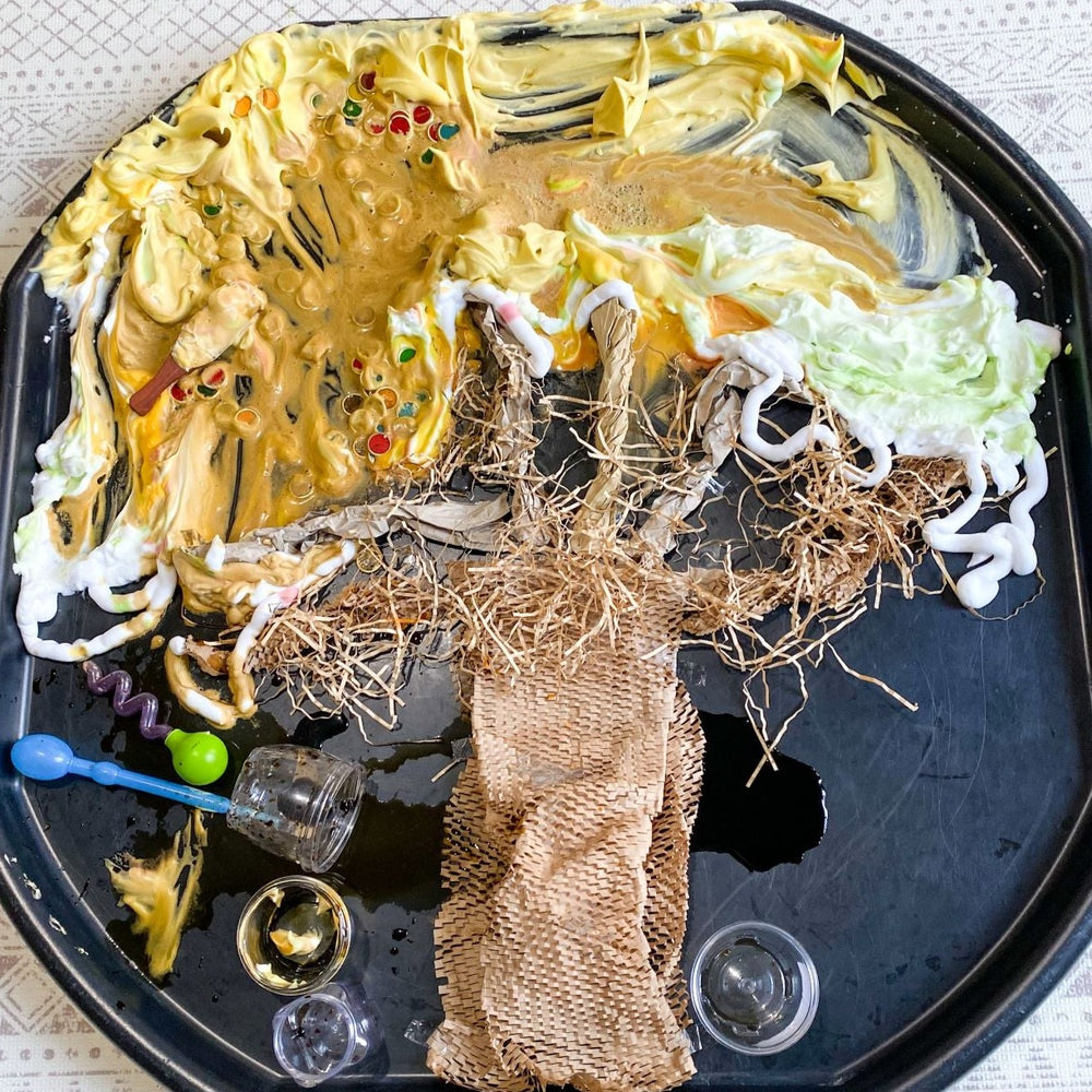 Autumn play with messy and sensory materials in shape of autumn tree on a black tuff tray